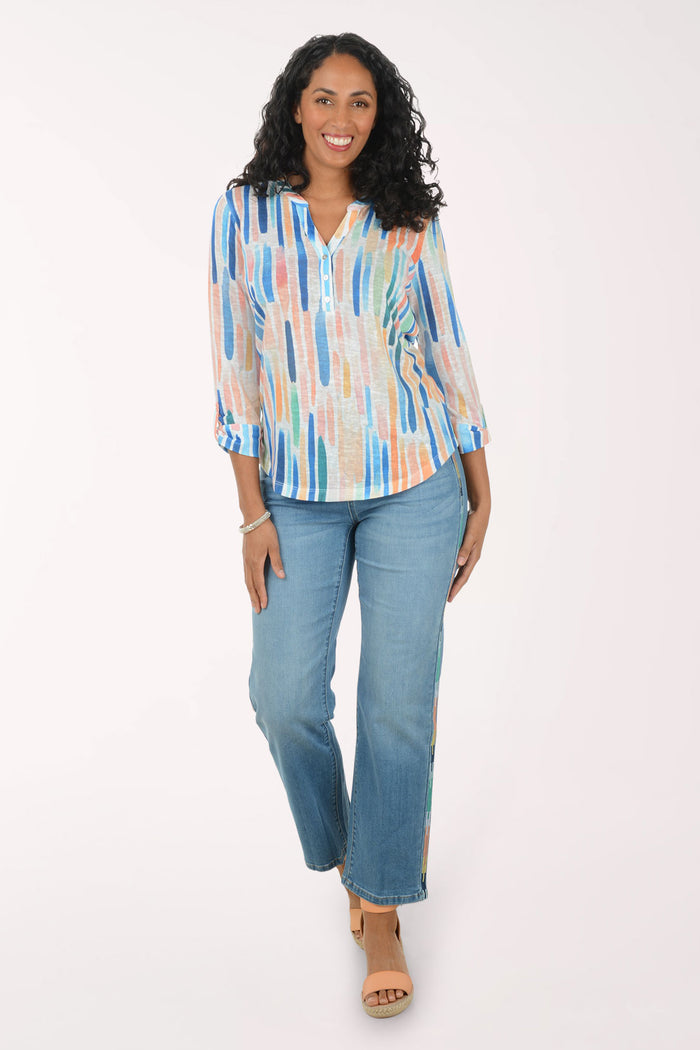 Woman wearing a colorful striped shirt and blue jeans on a white background
