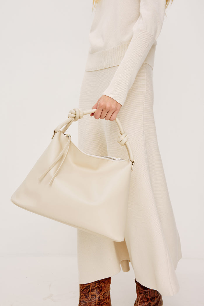 Siena Slouchy Hobo Bag in Italian Leather With Knotted Top Strap, Zipper Closure With Fringe Tassel And Interior Snap Button Slip Pocket in Bone Colorway - Stylized on Model Featured