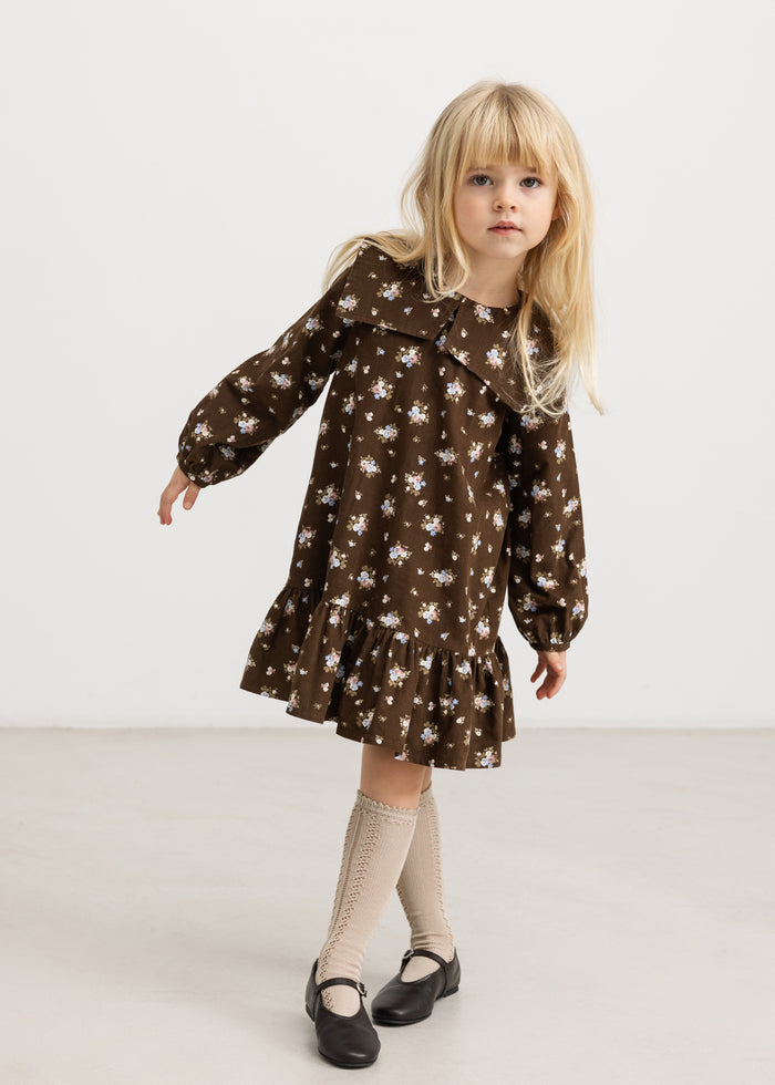 Brown dress with floral print, long sleeves and a slightly flared skirt.