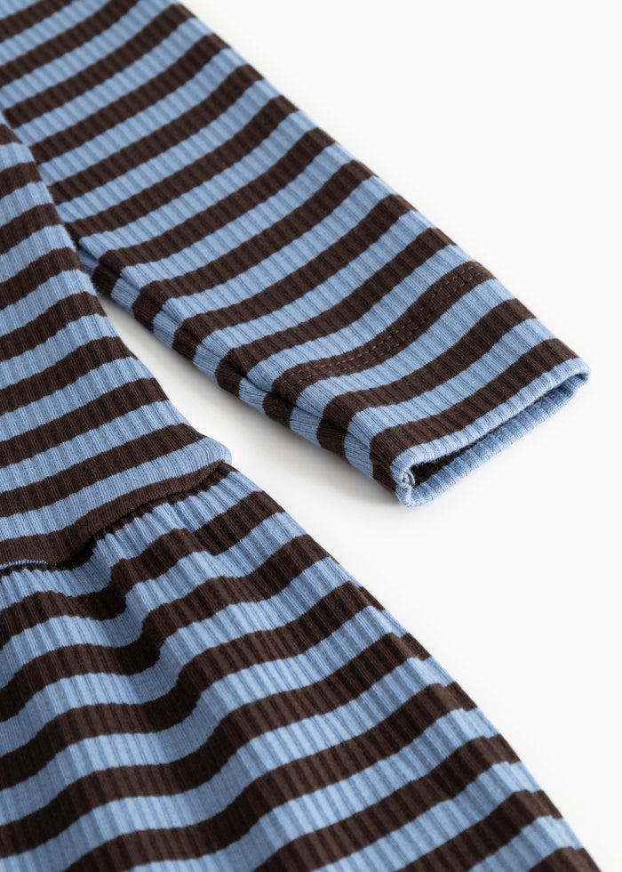 Detail on dress with dark brown and light blue stripes, slightly wrinkled edge.