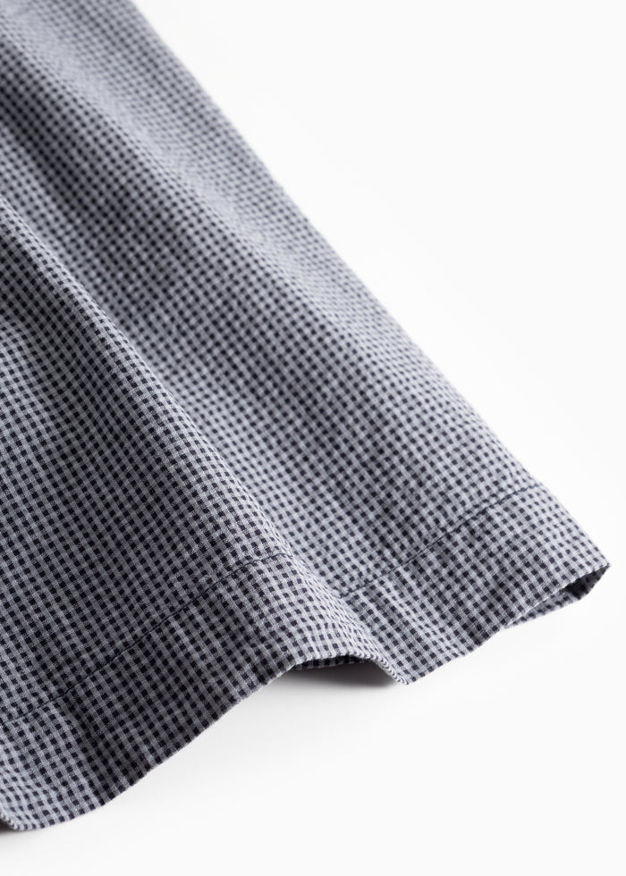 Netted skirt fabric in blue and black with a wavy hem seam and a light pleated edge.