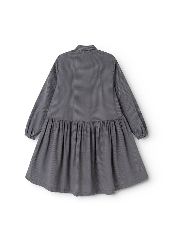 Dark gray dress seen from behind with a high collar and a pleated skirt bottom.