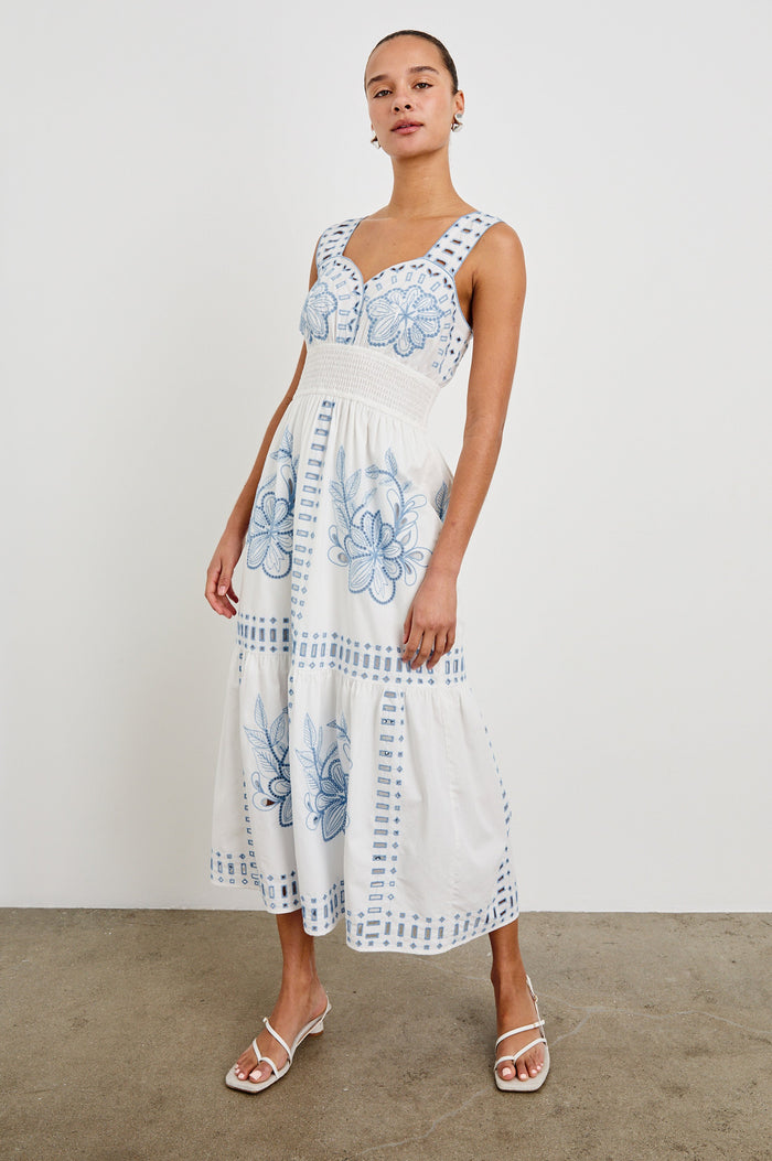 Front view of model wearing our sleeveless, Fawn Midi Dress in White with Blue Embroidery contrast and eyelet details.
