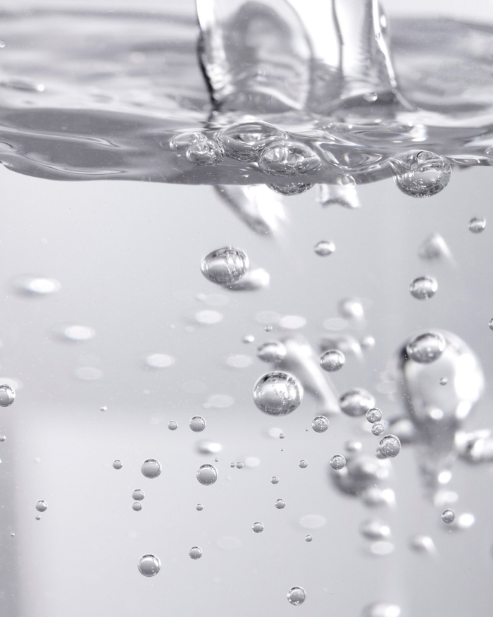 Close-up of clear liquid bubbles rising in water, representing the fresh and hydrating qualities of Fresh Start Lime Pearl + Prickly Pear 5% PHA Resurfacing Treatment | Three Ships skincare product.