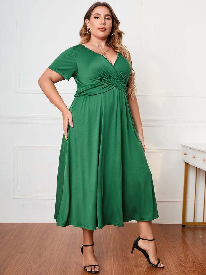 Green plus size short sleeve dress with V-neck and gathered waist worn by woman with black heels