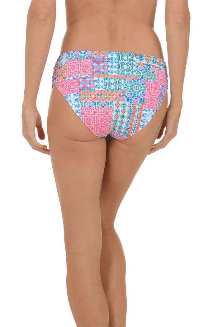 A woman wearing a multli-colored swim brief. Back shot.