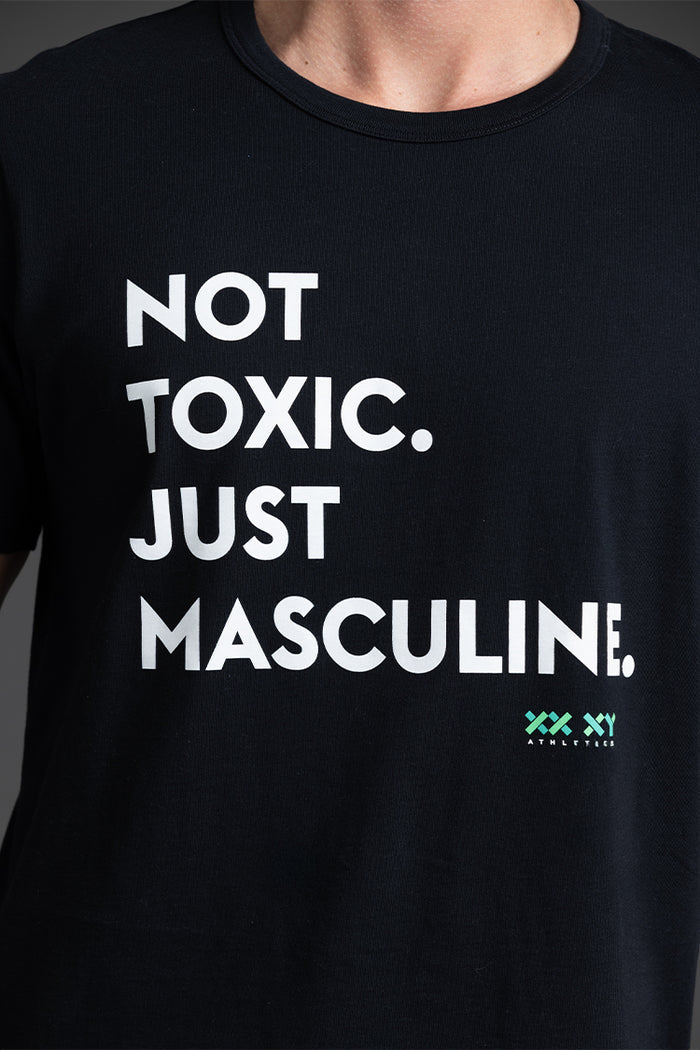 Black t-shirt with white text 'NOT TOXIC. JUST MASCULINE.' and a logo on a dark background || Black