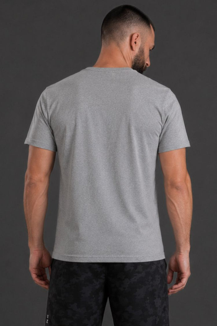 Man wearing a gray t-shirt and black pants against a dark background || Light Heather Gray