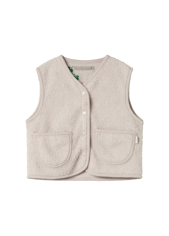 Beige teddy-vest med knaplukning, forlommer og grønne kløverdetaljer ved kraven