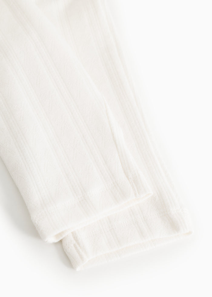 White baby pants from Pitti with a slightly smooth cuff at the bottom and a fine vertical texture.