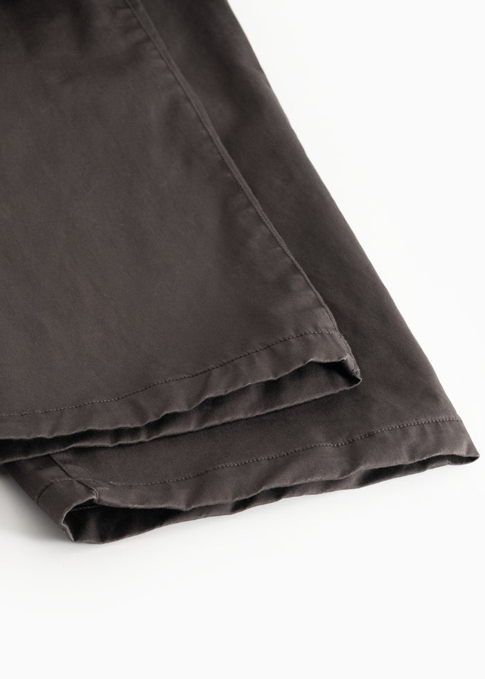 Dark pants with cuffs at the bottom and visible seam at the leg ending.