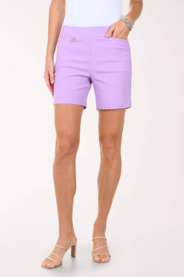 A woman wearing a light purple short against a light pink background