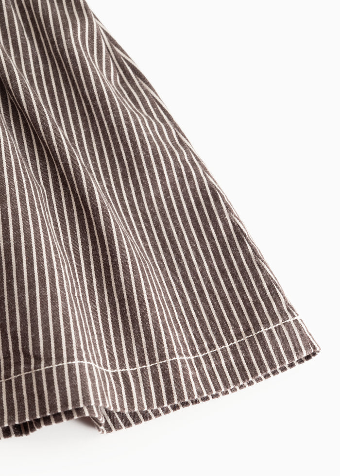 Dark brown striped dress edge with uniform stripes and small ruffles at the bottom.