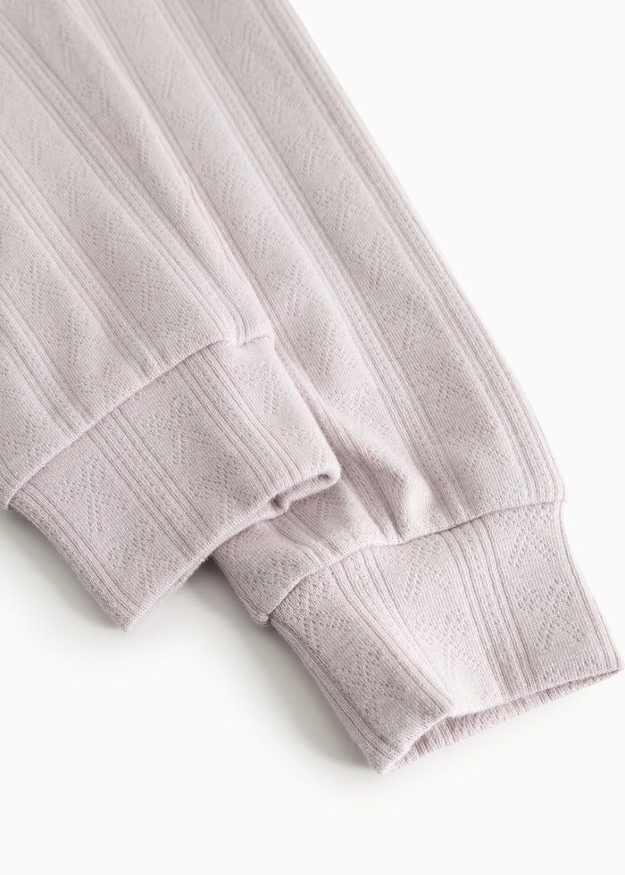 Children's pajamas in light purple with ribbed edge and textured stripe pattern at the cuff.