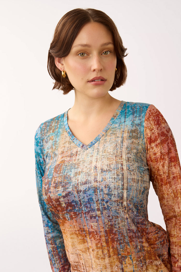Woman wearing a 3/4 sleeve multicolored v-neck top