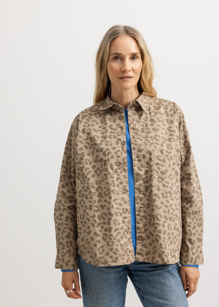 Brown leopard print blouse with button closure and blue trim.