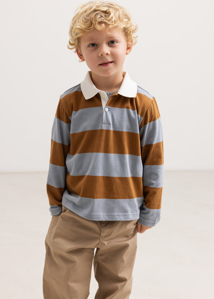 Children's polo shirt with long sleeves in light blue and ochre brown stripes, the child wears it.