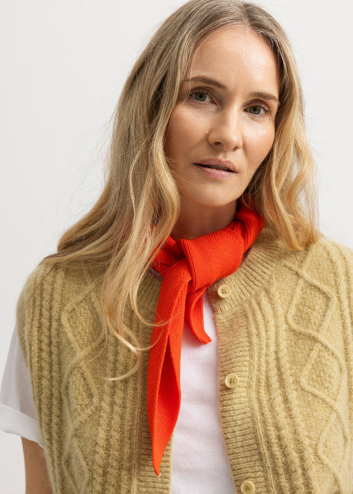 Light blue knitted vest with window pattern and button closure, worn over a shirt