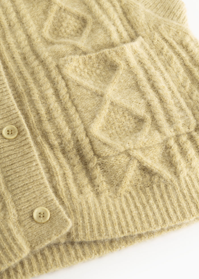 Details of a light yellow striped vest with a checkered pattern and snap buttons at the cuffs.
