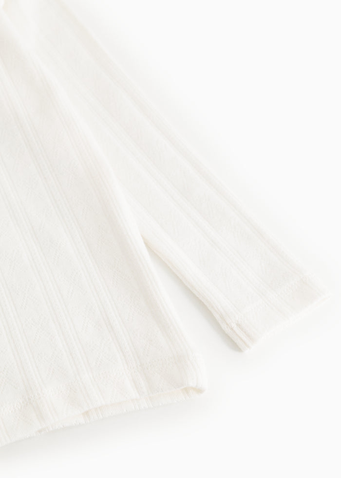 Long-sleeve white T‑shirt with lightly structured fabric and ribbed cuff at the sleeve ending.