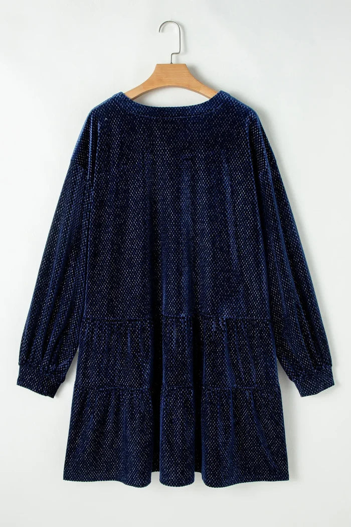Navy blue textured velvet dress for curvy women with long sleeves hanging on wooden hanger