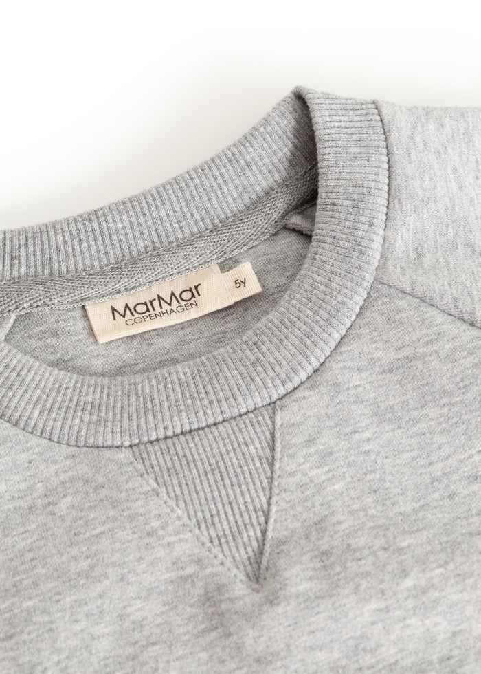 Gray sweatshirt blouse with rib collar and inner label at the neckline.