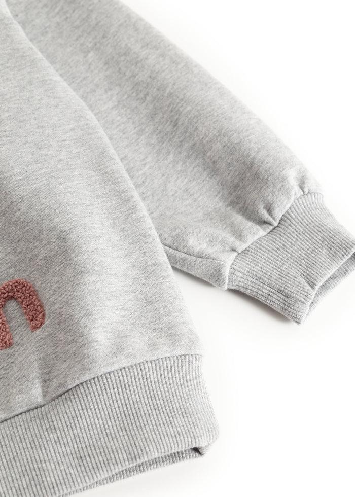 Gray sweatshirt blouse with ribbed cuffs and a wide hem.