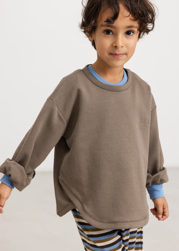 Dusty brown blouse with blue contrast trim at the collar and sleeves.