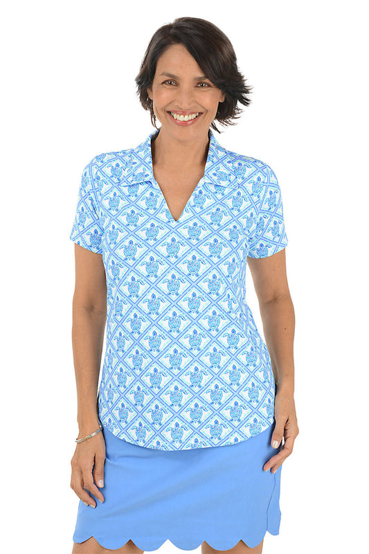 Woman wearing a blue patterned top and skirt on a white background.
