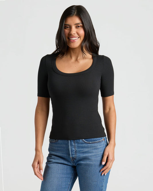 Woman in Womens Black Ribbed 3/4 Sleeve Scoop Neck Tee, smiling. MODEL_INFO: Sophia is 5'8", wearing a size XS