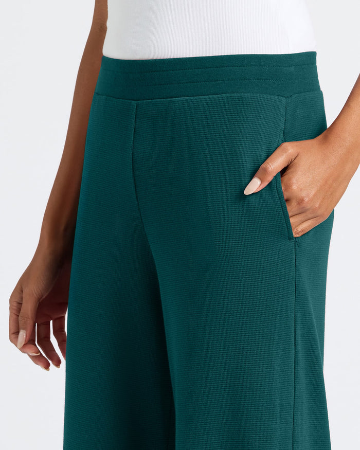 Person wearing Womens Deep Emerald Waffle Long Sleeve Henley & Waffle Leg Pant, showcasing its textured knit and relaxed fit.